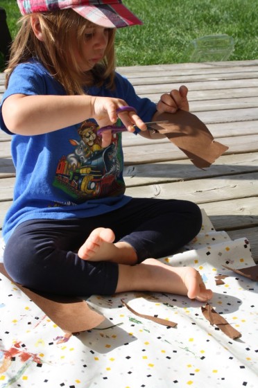 preschooler cutting out paper footprints