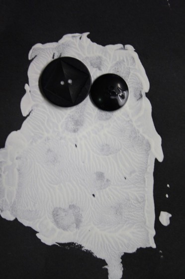 ghost printed on black paper with button eyes by preschooler