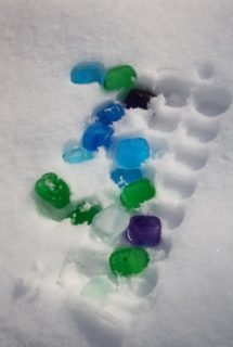 playing with coloured ice cubes in the snow