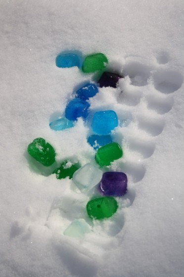 blue, and green coloured ice cubes in snow