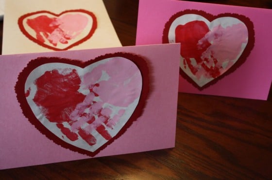 3 valentines cards with red and pink hand prints shaped like hearts