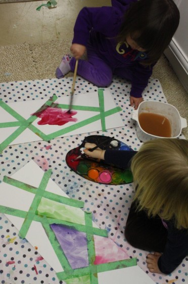 Several children making tape resist art at daycare