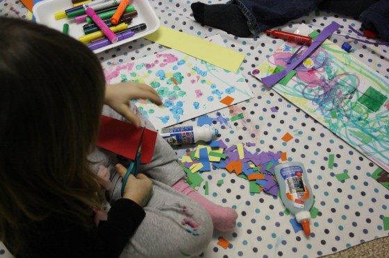 Preschooler cutting paper with safety scissors
