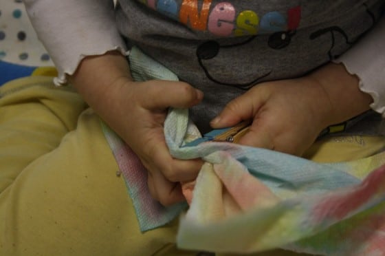 toddler putting paper towel into clothespin