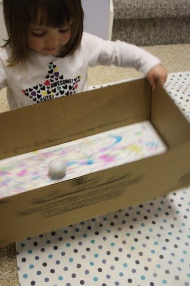 golf balls and paint in a box for making an easter craft garland