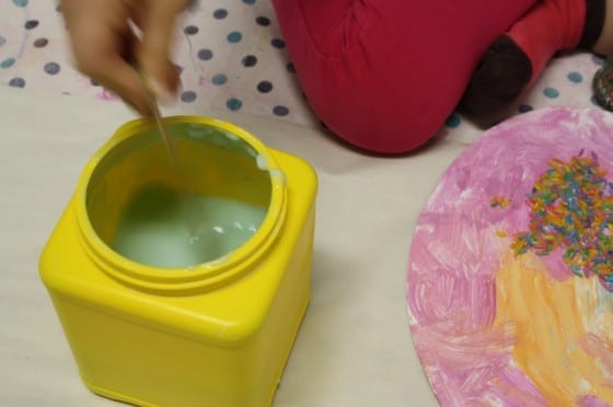 child stirring jar of glue