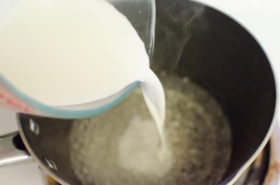 pouring cornstarch into vinegar and water on stovetop