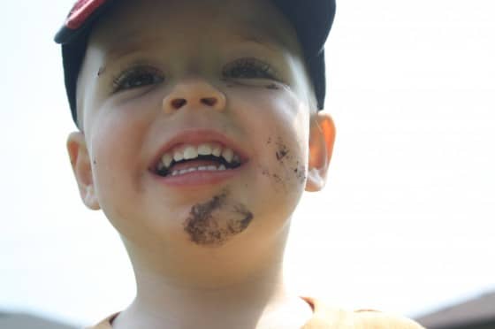 smiling toddler with mud on face