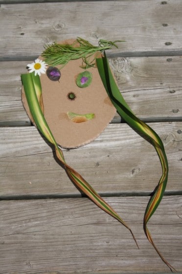 face with flowers and long grass hair on cardboard
