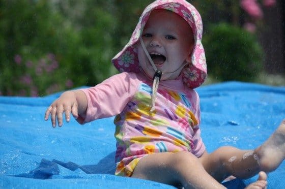 toddler on backyard water slide