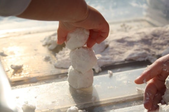 child making snowman with clean mud