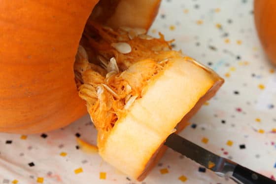 pulling guts out of pumpkin from the bottom