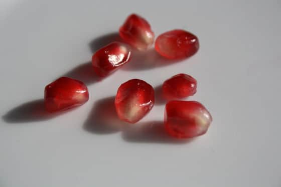 7 pomegranate seeds on white background