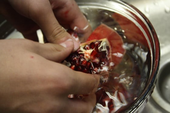 removing pomegranate seeds in bowl of water