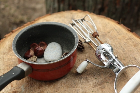 pot with stones and chestnuts beside whisk