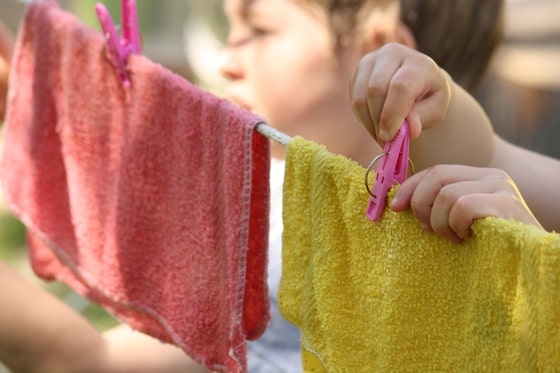 toddlers pinning cloths to clothesline