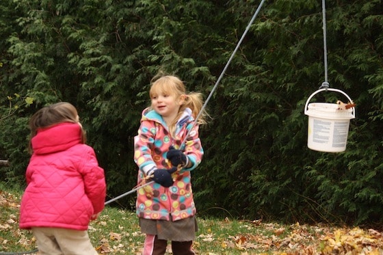 preschoolers pulling on rope to raise bucket