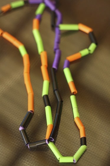 Halloween necklaces made with orange, green, purple and black straws