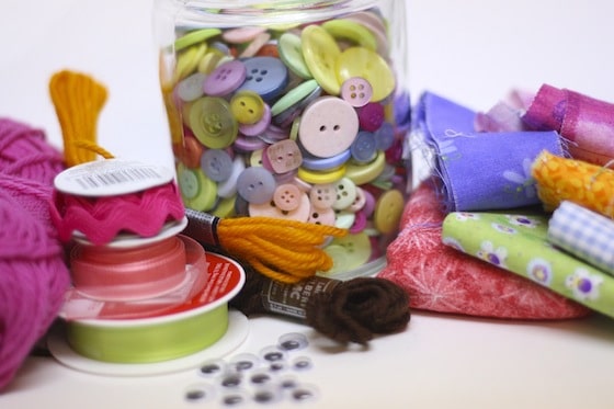 buttons, ribbon, fabric scraps and wool for making homemade paper dolls