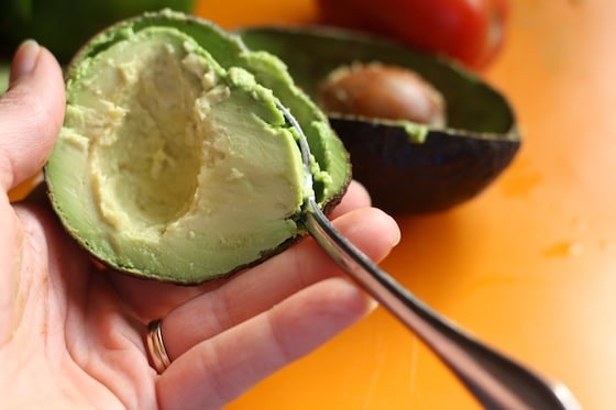 scooping flesh from an avacado