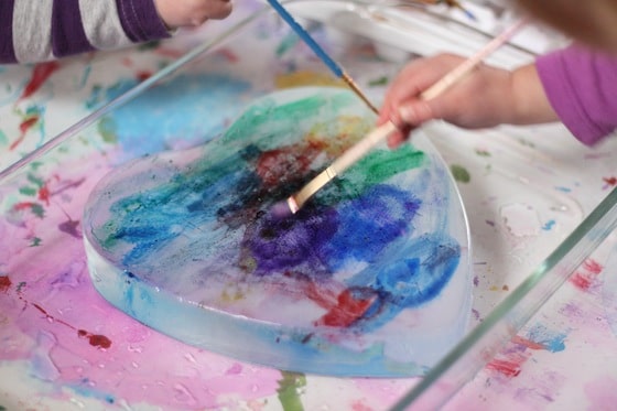 Ice painting activity with a frozen heart and liquid watercolours