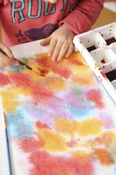 toddler painting paper towel with watercolours