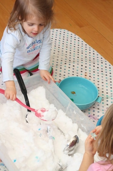 toddlers digging for "diamonds" in a snowy sensory bin