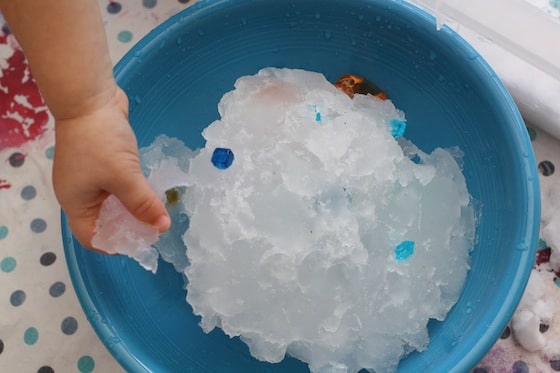snow turning to slush and ice in a bowl of water