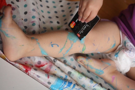toddler painting her legs