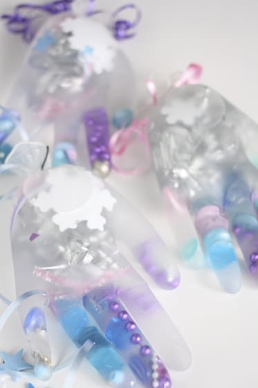 latex gloves filled with water and pink, purple and blue beads, buttons and ribbons