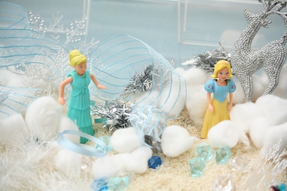 close up rice, cotton balls, anna and elsa figures in plastic bin