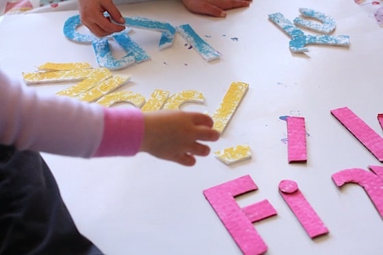 toddlers doing homemade name puzzle