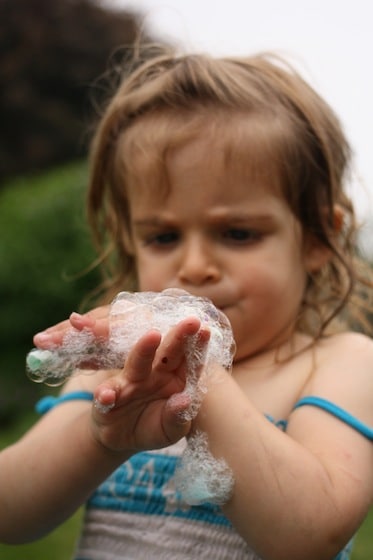 toddler using homemade bubble pipe