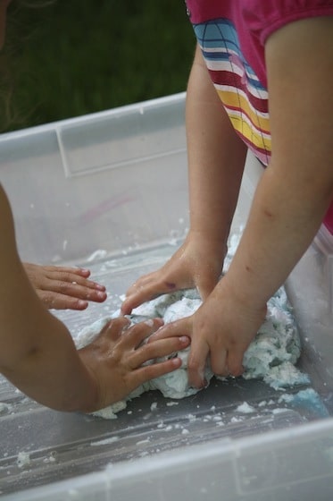 girls mixing frozen clean mud with hands
