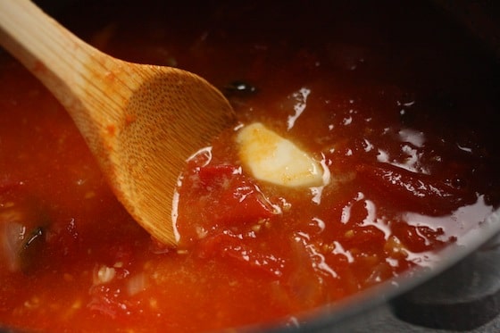 stirring butter into cooked tomatoes