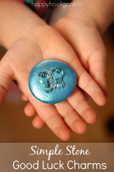 Preschooler's hands holding blue good luck stone with butterfly gem