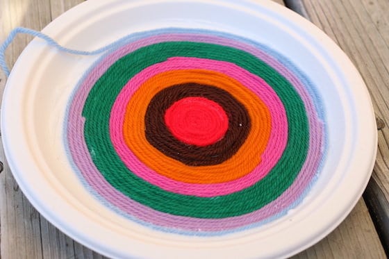 Making art on a paper plate with yarn 