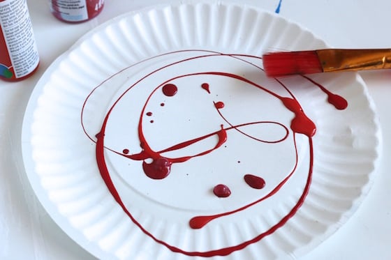 red paint dripped on a paper plate