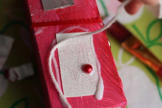 Gluing door on red gingerbread house