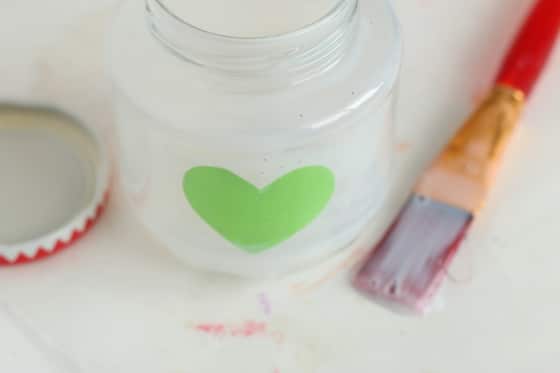 glass jar brushed with glue and contact paper heart stuck inside