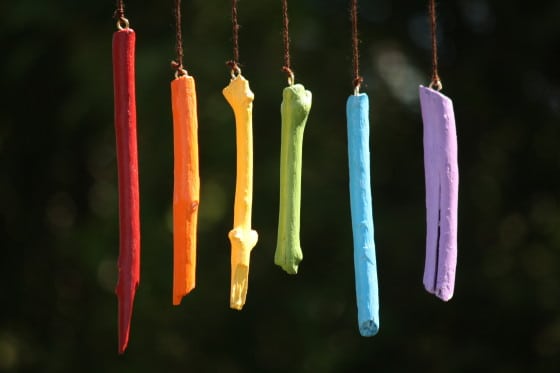 homemade rainbow wind chimes hanging from tree in backyard