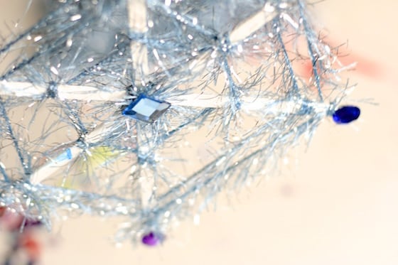 blue yarn snowflake with stir sticks, fuzzy yarn and craft jewels