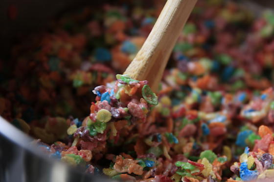 Stirring fruity pebbles and marshmallows with wooden spoon
