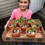 child holding tray of brownie flowerpot cakes