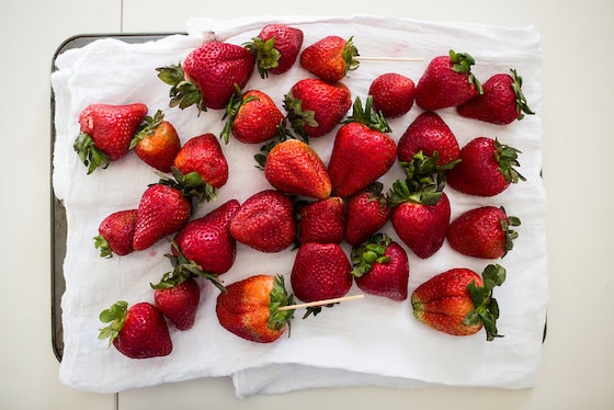 fresh strawberries drying on a tea towel