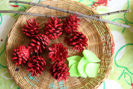 bowl of painted red pinecones and green felt leaves