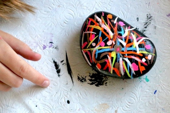 Rock painted black and decorated with liquid chalk markers