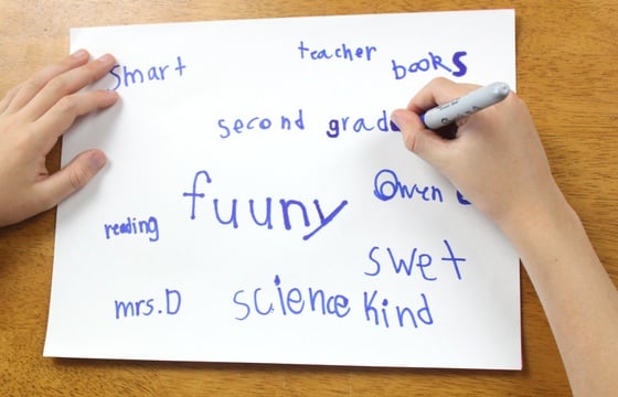 Child writing words on piece of paper