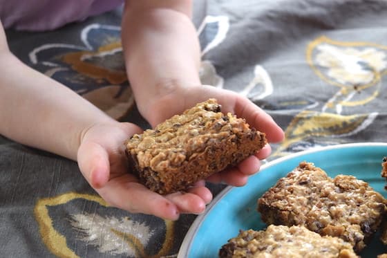 toddler holding homemade oatmeal bars with chocolate chips