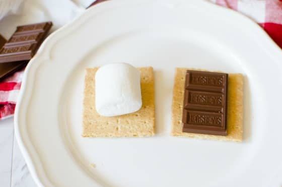 graham cracker with marshmallow and hershey's bar on white plate